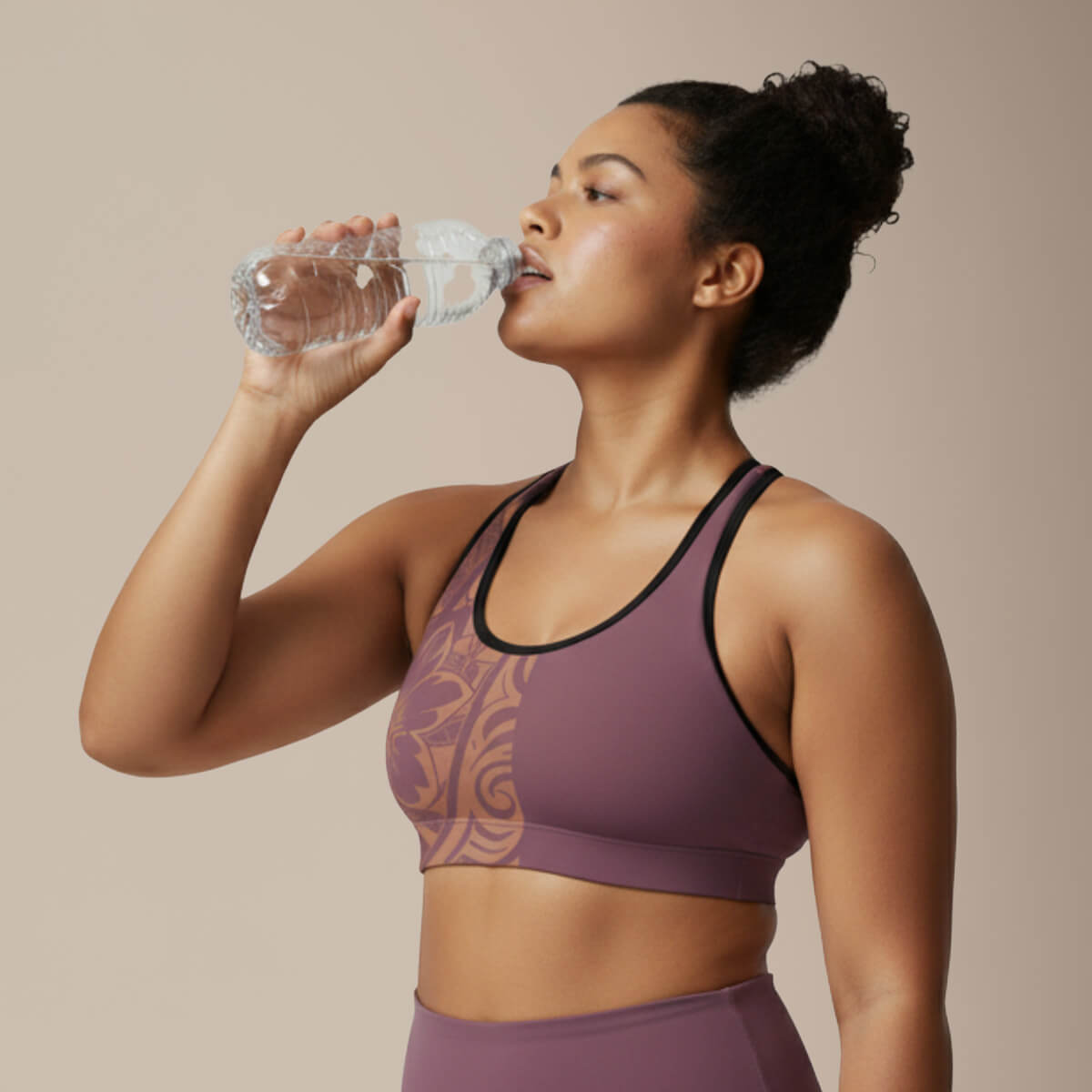 Black seamless sports bra with white stitching from Miami Sublimation, shown with high-waisted IslandRise leggings in Brandied Melon color.
