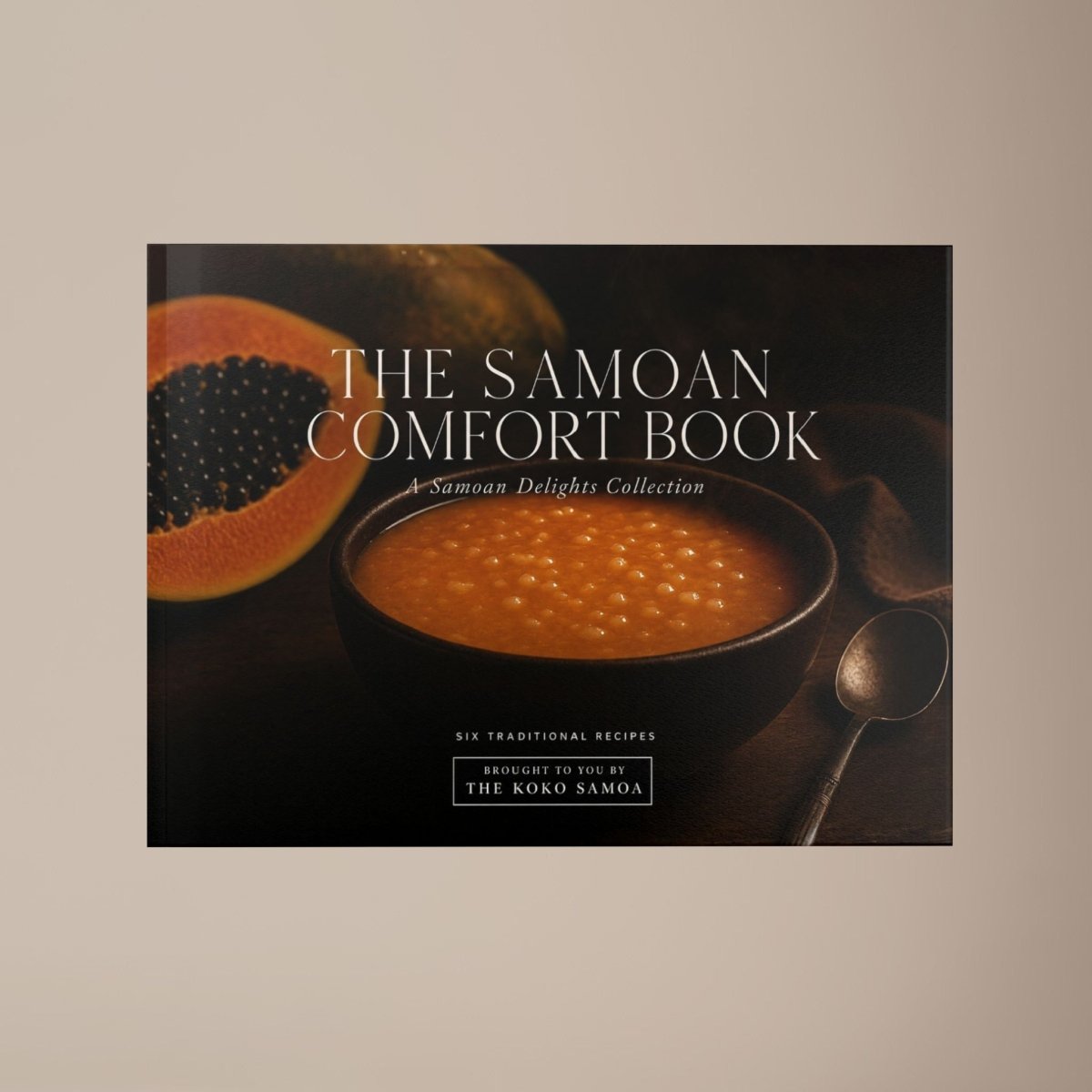 Hardcover keepsake book featuring 6 Samoan recipes, titled "The Samoan Comfort Book," by District Photo, with vibrant cover art.