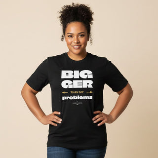 Soft unisex T-shirt by The Print Bar with "Bigger Than Problems" design, worn by a person, showcasing casual style.